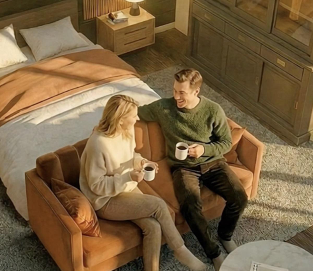 Couple sharing coffee on a couch beside the bed inside the treehouse